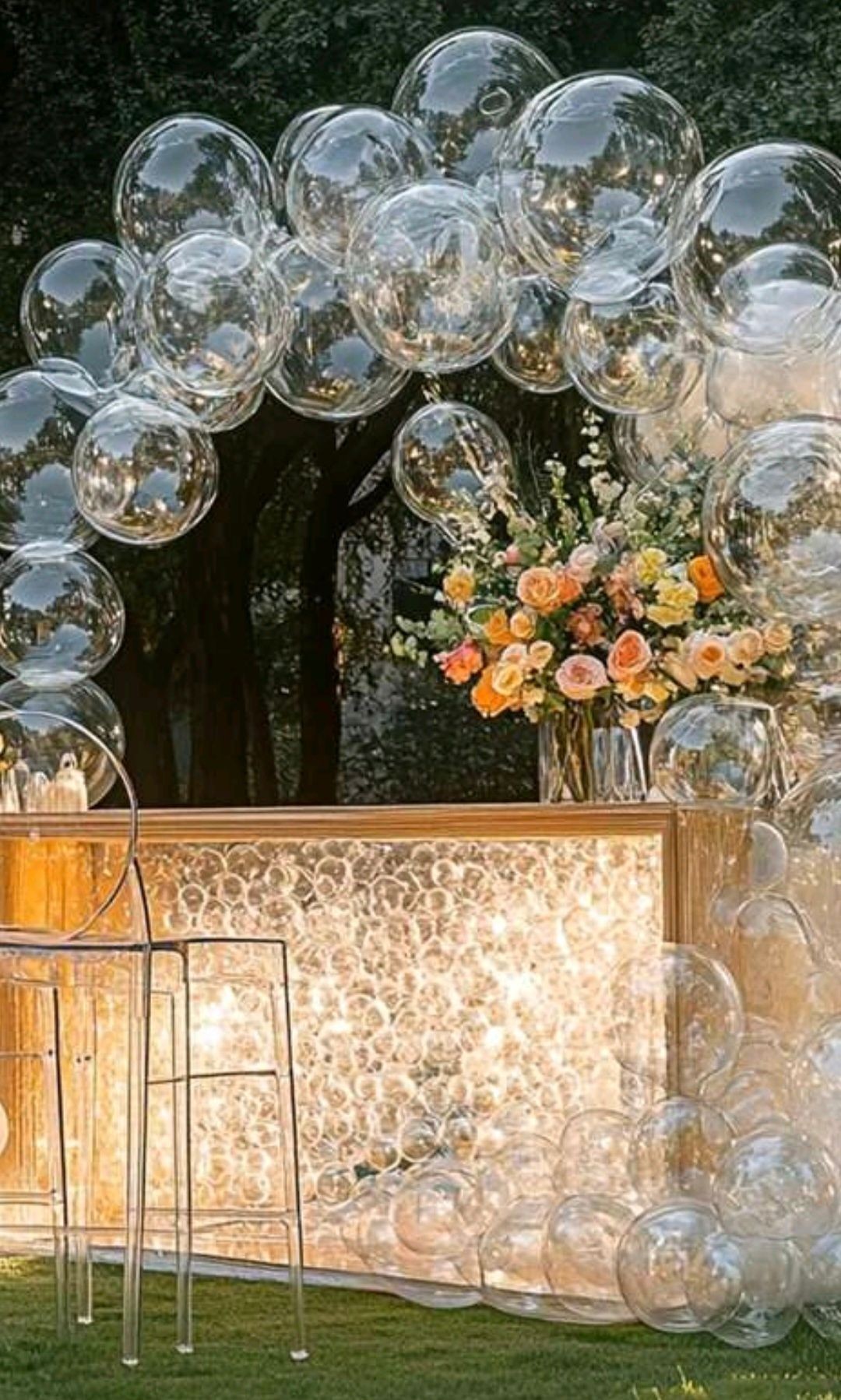 I stand with clear balloons around it and a roast base on top of gold stand long gold stand